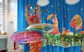 pani w kolorowym ubraniu i peruce kręci dużą ilością hula hoop 
