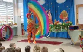 pani w kolorowym ubraniu i peruce porusza kolorowymi szarfami