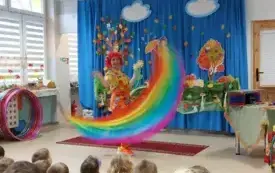 pani w kolorowym ubraniu i peruce porusza kolorowymi szarfami