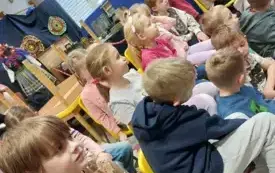 dzieci siedzą na krzesełkach