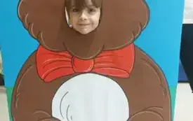 chłopiec z buzią w fotobudce w kształcie brązowego misia