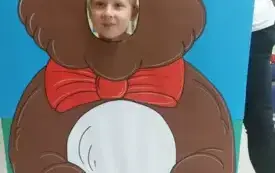 dziewczynka z buzią w fotobudce w kształcie brązowego misia