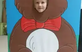 dziewczynka z buzią w fotobudce w kształcie brązowego misia