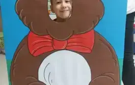 chłopiec z buzią w fotobudce w kształcie brązowego misia