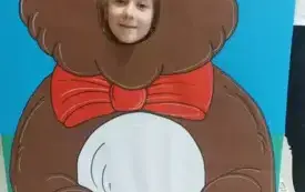 dziewczynka z buzią w fotobudce w kształcie brązowego misia