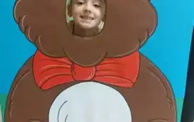 dziewczynka z buzią w fotobudce w kształcie brązowego misia
