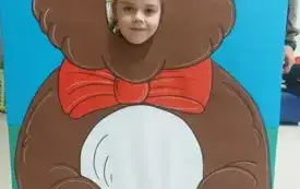 dziewczynka z buzią w fotobudce w kształcie brązowego misia