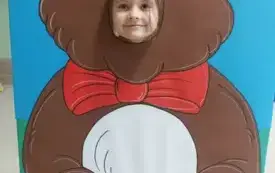 dziewczynka z buzią w fotobudce w kształcie brązowego misia