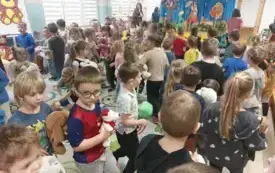 dużo dzieci stoi na sali dzieci trzymają maskotki