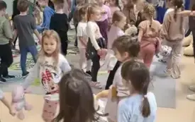 dzieci na sali tworzą koła trzymając się za ręce