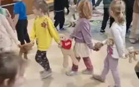 dzieci na sali tworzą koła trzymając się za ręce