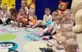 dzieci siedzą w kole w tle dekoracja dzień pluszowego misia