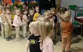 dzieci ustawione na dywanie w tle pani oraz jesienna dekoracja