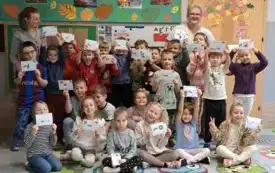 grupa dzieci pozuje do zdjęcia wraz z paniami kt&oacute;re stoją po obu stronach grupy