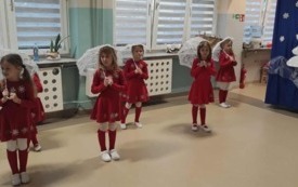 pięć dziewczynek w czerwonych sukienkach z białymi koronkowymi parasolkami
