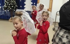 cztery dziewczynki w czerwonych sukienkach z koronkowymi białymi parasolkami jedna z dziewczynek wyraża zdziwienie