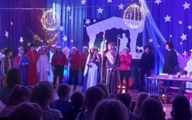 na scenie stoją trzej kr&oacute;lowie, Maryja J&oacute;zef aniołki diabły pasterze i panie w czapkach mikołaja