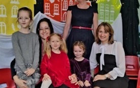 trzy dziewczynki trzy panie pozują do zdjęcia na tle kolorowych domk&oacute;w
