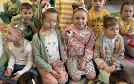 dzieci siedzą na dywanie