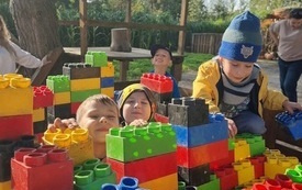 dzieci bawią się ogromnymi kolorowymi klockami 