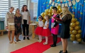 trzy panie po prawej stronie na środku dwie odświętnie ubrane dzieczynki po lewej stronie pani dyrektor i pani nauczycielka