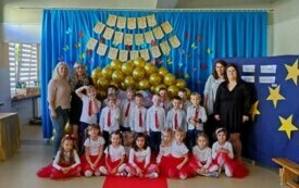 dzieci ustawione do zdjęcia grupowego dzieci z przodu siedzą z tyłu stoją po bokach nauczycielki i opiekunki grupy w tle złote balony i napis Dzień Edukacji Narodowej