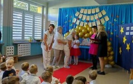 panie kucharki stoją przy czerwonym dywanie obok pani dyrektor i po bokach nauczycielki z grupy V