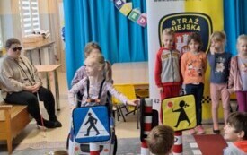 dzieci na tla dekoracji z numerem alarmowym dziewczynka w stroju auta