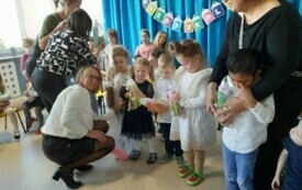 dzieci z upominkami pozują do zdjęcia w towarzystwie pań nauczycielek