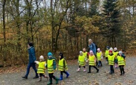 grupa dzieci w trakcie spaceru z nimi dwie panie nauczycielki