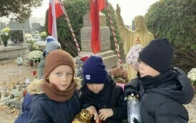 Trzech chłopc&oacute;w odpala znicze 