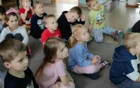 Dzieci siedzą patrząc na film