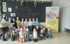 Dzieci i panie pozują do zdjęcia w grupie. 