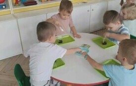 Dzieci pracuja przy stoliku. 