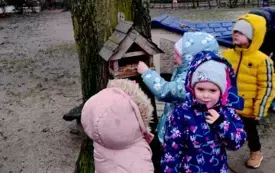 grupka dzieci przed karmnikiem