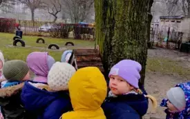 grupa dzieci przed karmnikiem w ogrodzie