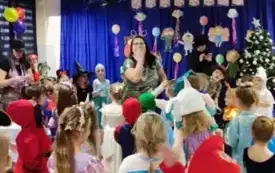 dzieci w strojach karnawałowych przed nimi pani nauczycielka coś pokazuje