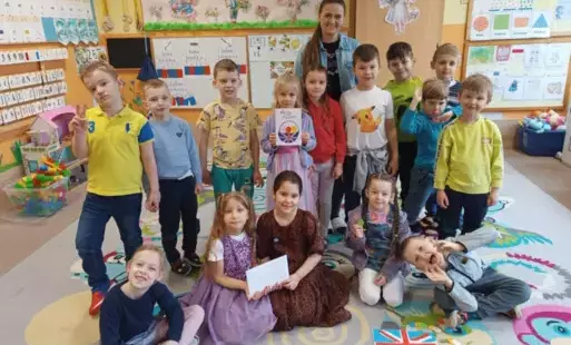 grupa dzieci wraz z nauczycielką pozuje do zdjęcia