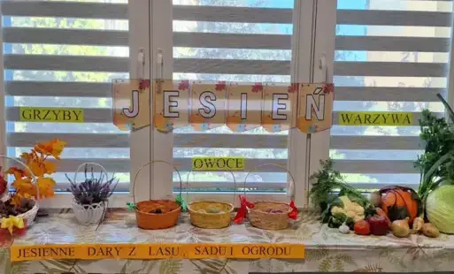 napis jesień zawieszony na oknie na parapecie leżą różne dary jesieni owoce warzywa grzyby kasztany