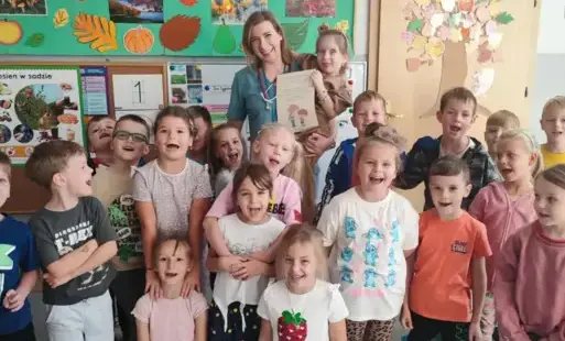 dzieci pozują do zdjęcia grupowego wraz z panią pielęgniarką
