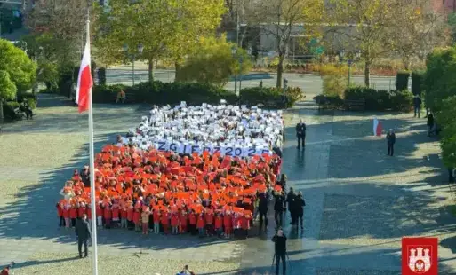 flaga biało czerwona stworzona na placu z ludzi dookoła patriotyczne elementy