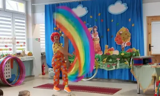 pani w kolorowym przebraniu macha kolorowymi szarfami
